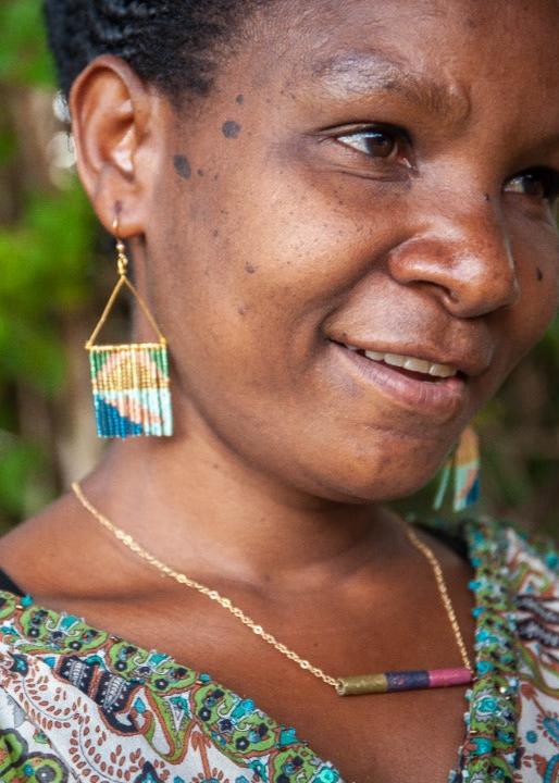 A DuHope artisan wearing handmade earrings