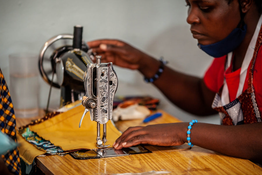 A DuHope participant sewing at a work table